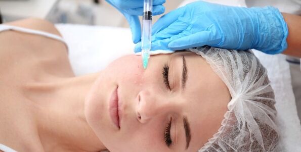Un'estetista esegue il ringiovanimento della pelle del viso utilizzando il plasma